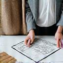 Two people reviewing architectural plans and plant samples, representing initial consultation.